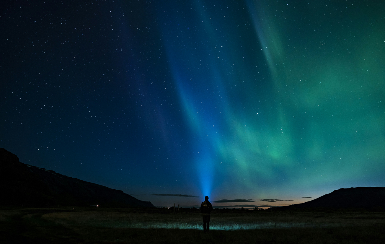 Person standing in front of the northern lights